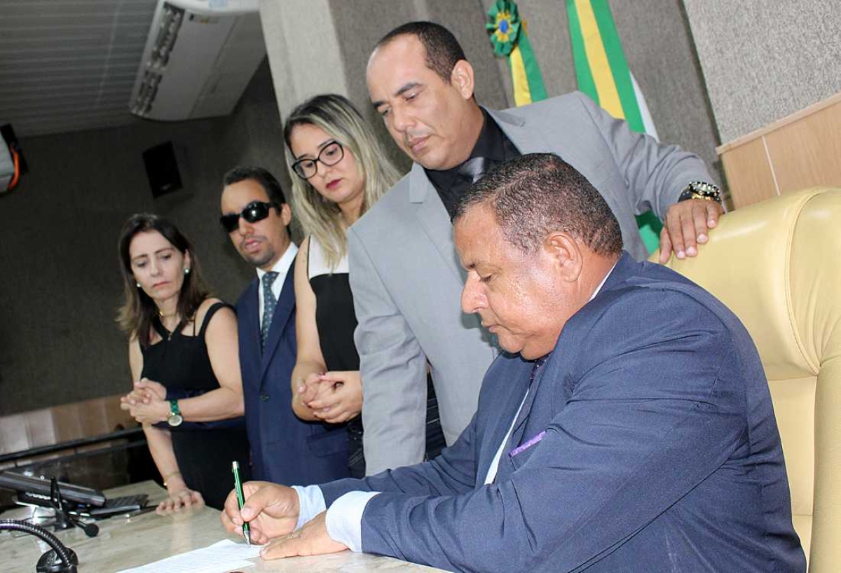 Presidente da sessão, Américo de Deus assina ata ao lado dos colegas parlamentares (Foto: Assessoria Lucas Aribé)