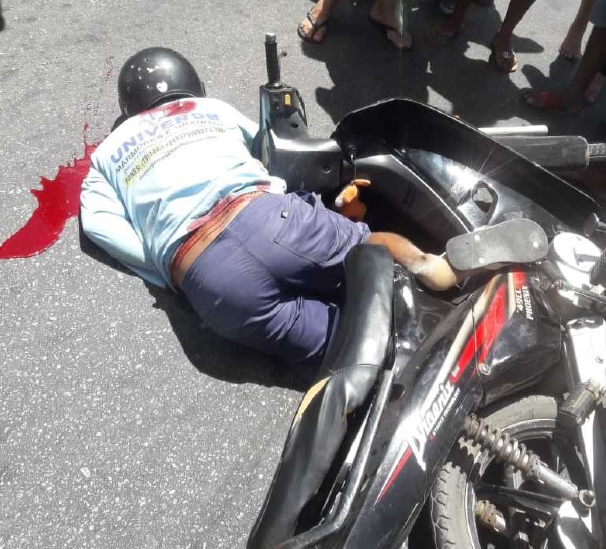 Rapaz é atingido por tiros e cai sobre o veículo que conduzia (Foto: Whatsapp/ Grupo Sergipe Notícias)