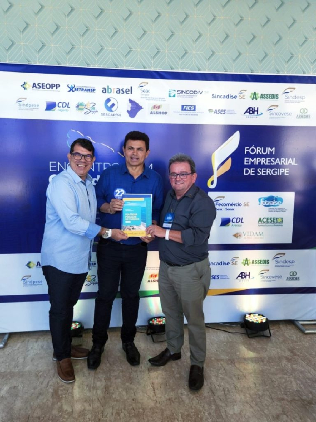 Candidato Valmir de Francisquinho recebe projeto Vai Turismo das mãos do presidente do sistema Fecomércio/Sesc/Senac, Marcos Andrade, e do vice-presidente, Alex Garcez.
Imagem: Ascom Fecomércio