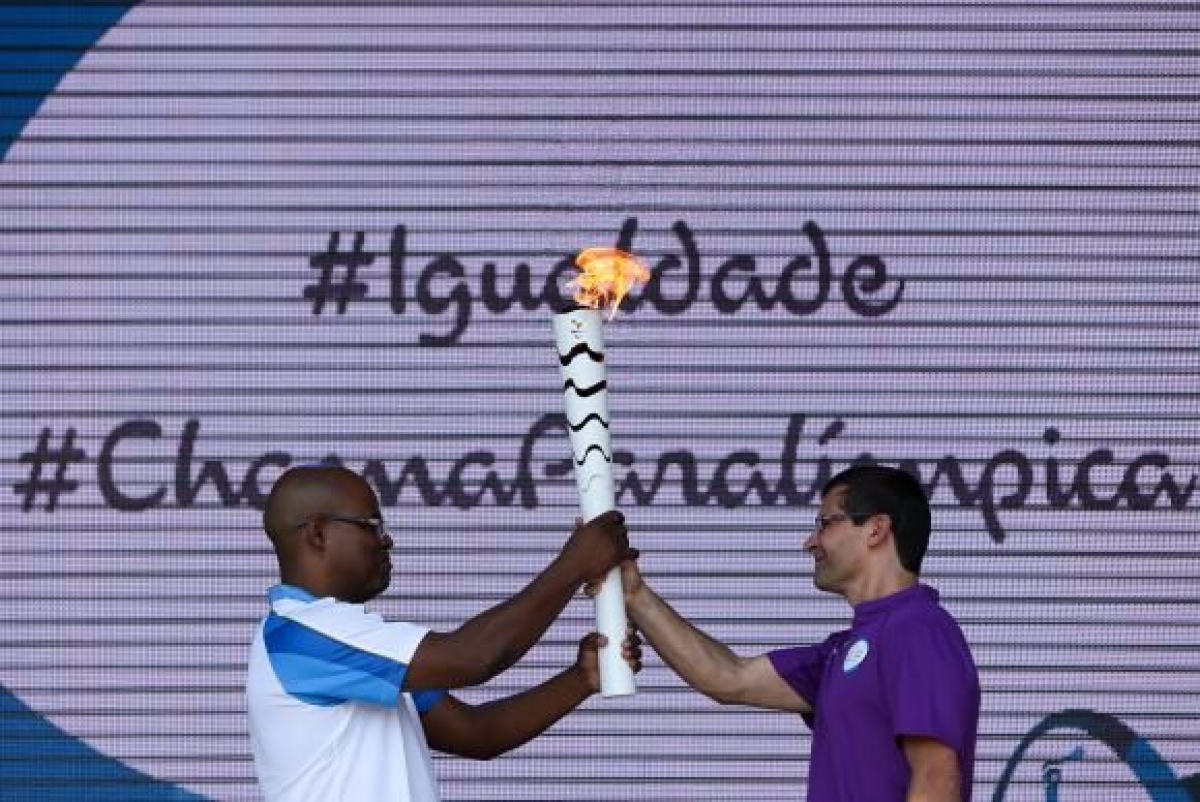 O mensageiro Ulisses de Ara�jo passa a tocha paral�mpica para o tetracampe�o de futebol de amputados, Cl�udio Irineu, e marca o in�cio do revezamento, em Bras�lia (Imagem: Marcelo Camargo/Ag�ncia Brasil)